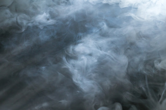 The stream of thick smoke on a dark background
