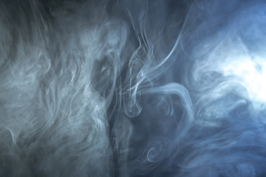 The stream of thick smoke on a dark background