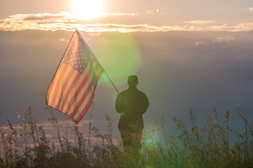 The military stand on the background of sunset with the American flag