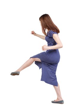 skinny woman funny fights waving his arms and legs. brunette in a blue striped dress beat someone down.
