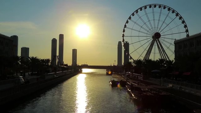 Al Qasba canal and ferris wheel in Sharjah city, United Arab Emirates. Sharjah - third largest and third most populous city in UAE, after Dubai, and the capital of the emirate of Sharjah