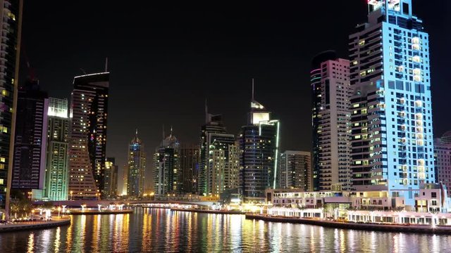 UHD 4K Dubai Marina night zoom out time lapse, United Arab Emirates. Dubai Marina - the largest man-made marina in the world, is a canal city, carved along a 3 km stretch of Persian Gulf shoreline
