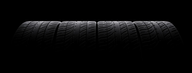 Tires in a row on black background