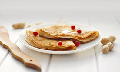 Homemade pancakes with honey and cranberry on white wooden table