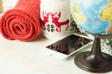 Smartphone, Cup, knitted scarf and a globe on wooden table