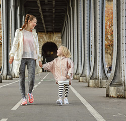 healthy mother and child on Pont de Bir-Hakeim bridge walking