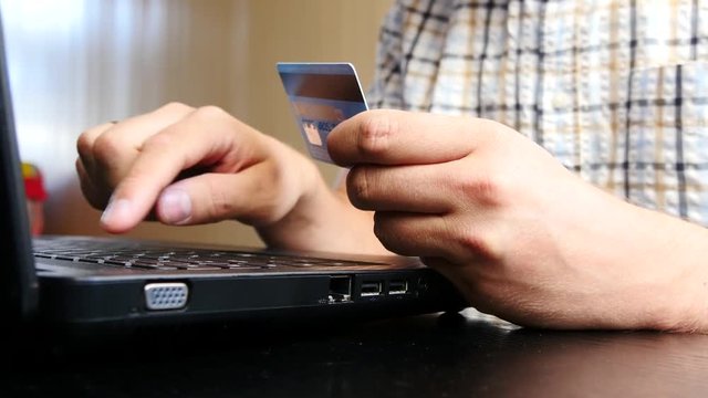 Man is using credit card and laptop for online payment. 4K UltraHD video