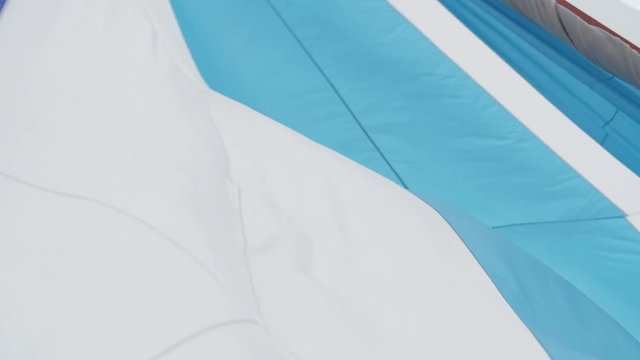 Multicolored Sailing in the wind through the waves. Full sails, very strong wind. Ocean race, real adventure. Real spray. Sun sails, and adventure. Sail blows in the wind on a boat. Slow motion shot.