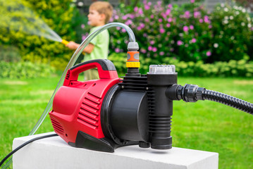 Modern water pump in garden on hot summer day