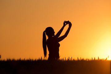 Silhouette of girl taking selfie