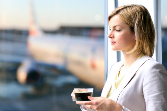 Portrait of business woman standing with coffee near window