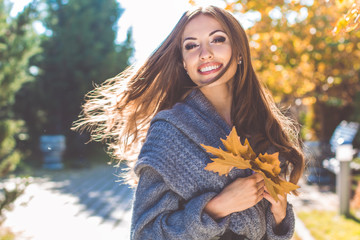Pretty woman in park with autumn yellow leaves