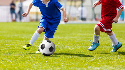 Obraz premium Young football players playing football soccer game. Running players