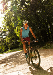 Obraz premium Young man riding a mountain bike on old country road.