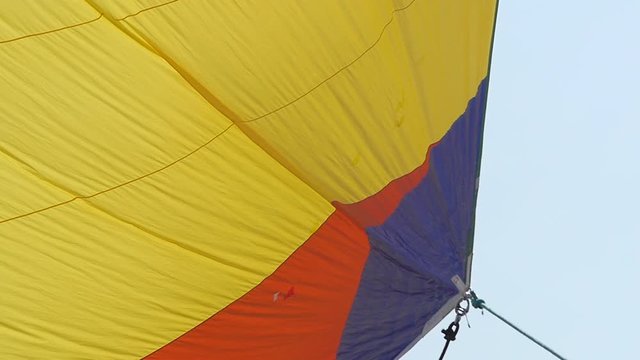 Multicolored Sailing in the wind through the waves. Full sails, very strong wind. Ocean race, real adventure. Real spray. Sun sails, and adventure. Sail blows in the wind on a boat. Slow motion shot.