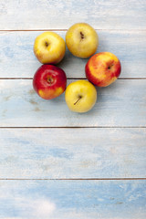 Fresh apples on blue wooden table, top view