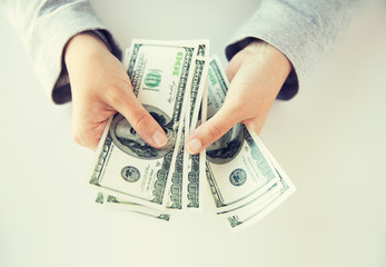 close up of woman hands counting us dollar money