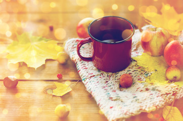 close up of tea cup on table with autumn leaves