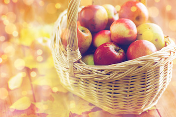 close up of basket with apples on wooden table