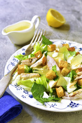 Healthy grilled chicken caesar salad with cheese and croutons.