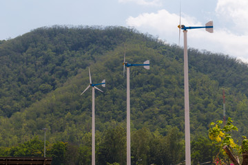 Fototapeta na wymiar Wind turbine blue sky background agianst mountain
