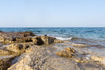 Sea wave splashing over the shore rocks with a high sea spray