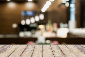 Wood table top on blur cafe restaurant with bokeh background
