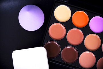 Palette concealer and correctors with sponge make up . Make-up base. Isolated on black background