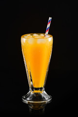 Orange juice glass on black background
