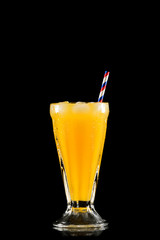 Orange juice glass on black background