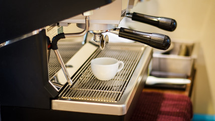 Close up espresso preparing in white ceramic cup from automatic coffee maker machine
