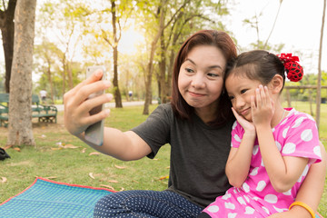Mother teach daughter taking selfie photo by smart phone
