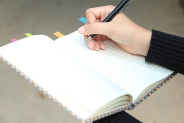 Woman hands check or writing on notebook. 