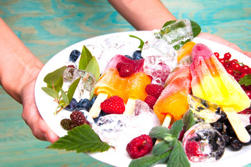 Hands serving delicious ice cream and fruits with ice cubes
