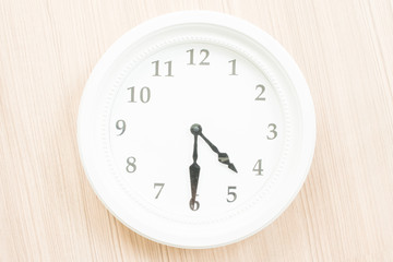 White clock on wood wall