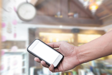 Hand holding smart phone over cafe background
