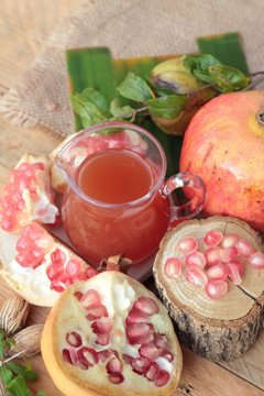 Ripe pomegranates with juice on wood background.