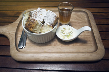 close up toast in a cup with icing sugar powdered on top, honey in a mug shot, put on wooden plate,wooden table,morning breakfast,honey toast menu