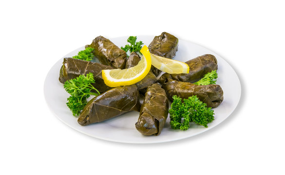 Dolma - stuffed meat in grape leaves with cream lemon on plate. White background