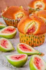 Figs muffins with fresh fruits on baking paper and wooden background