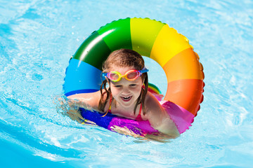 Little girl with toy ring in swimming pool