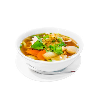 Hot and spicy Thai Dishes. A savoury thick soup made with squid rings, spices and vegetables and crushed peanuts isolated on white background. Selective focus
