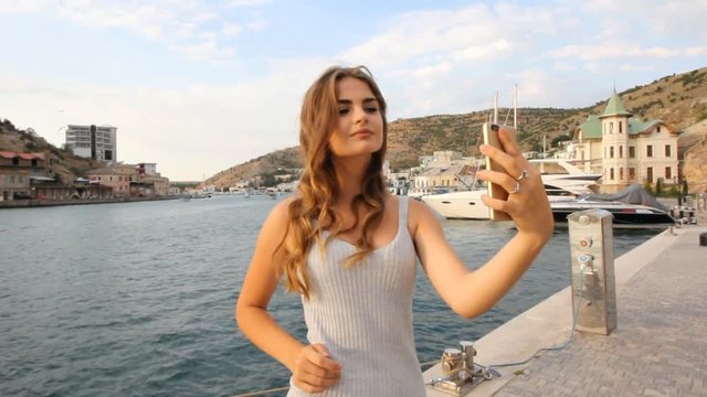 happy young sexy girl selfie is photographed on a mobile phone on vacation