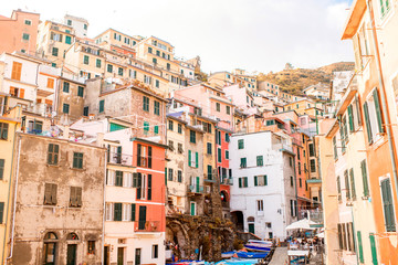 Fototapeta na wymiar Riomaggiore old town with colorful buildings on the coastal hill in a small valley in the Liguria region of Italy