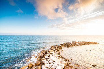 Fototapeta na wymiar Beautiful seascape with stony spit on the sunset
