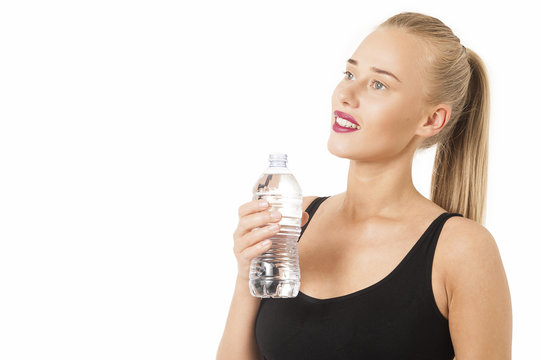 Portrait of young woman with a bottle of water. Healthy drink and sport concept. Skin care and beauty
