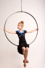 Little girl sits on a circus ring, white background