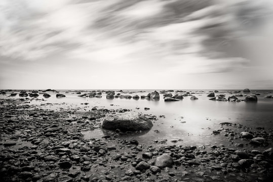 Pebbled beach with dramatic sky, black and white 