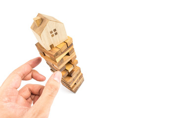 Hand picking up building block with House on top. House construction concept.Business risk concept