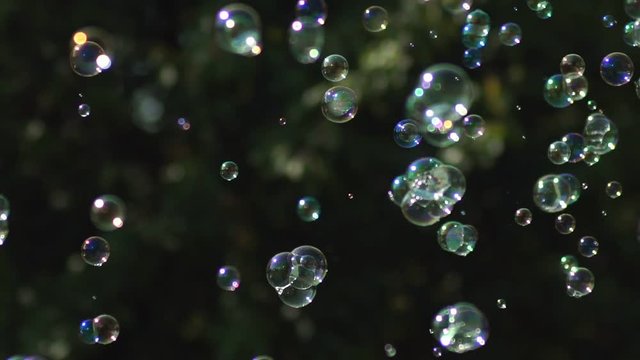 A lot of small and big multi-colored bubble blower. Soap bubbles show.